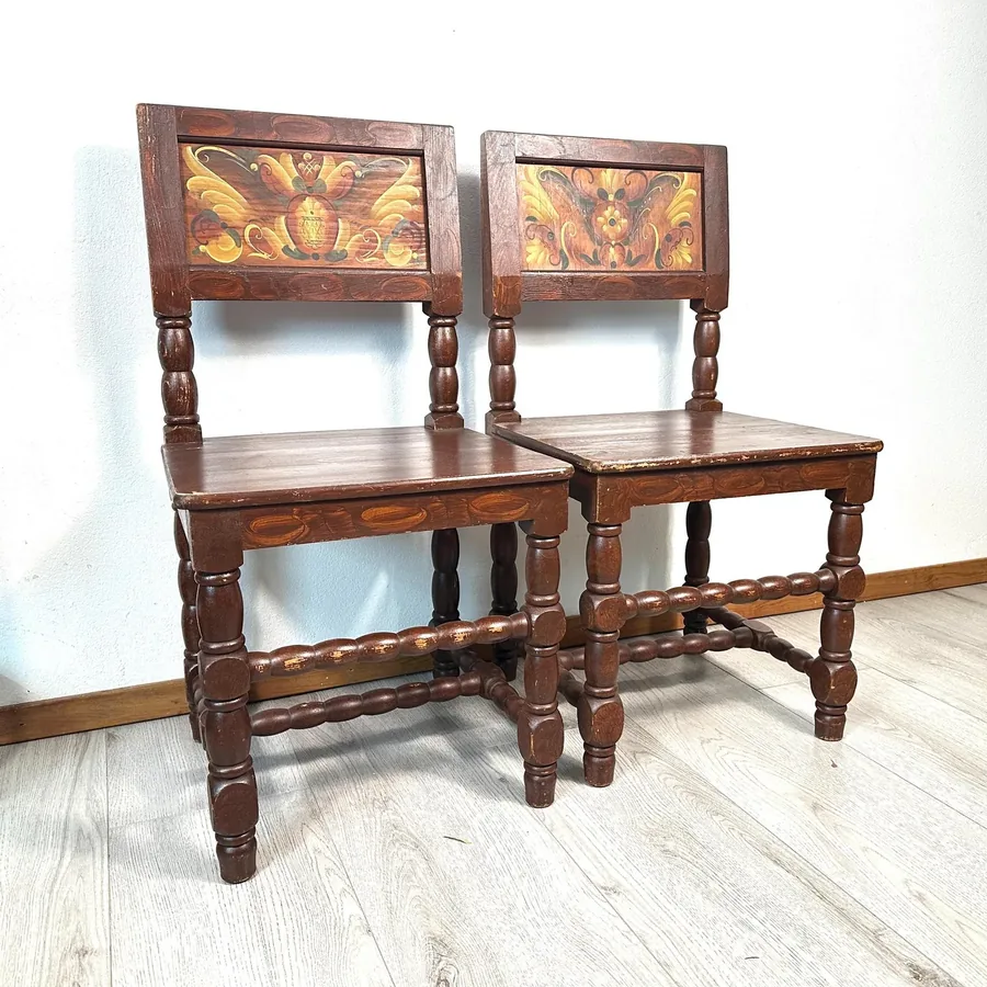 Pair of antique Swedish Kurbits chairs with hand-painted floral folk art backrests, turned wooden legs, early 20th century