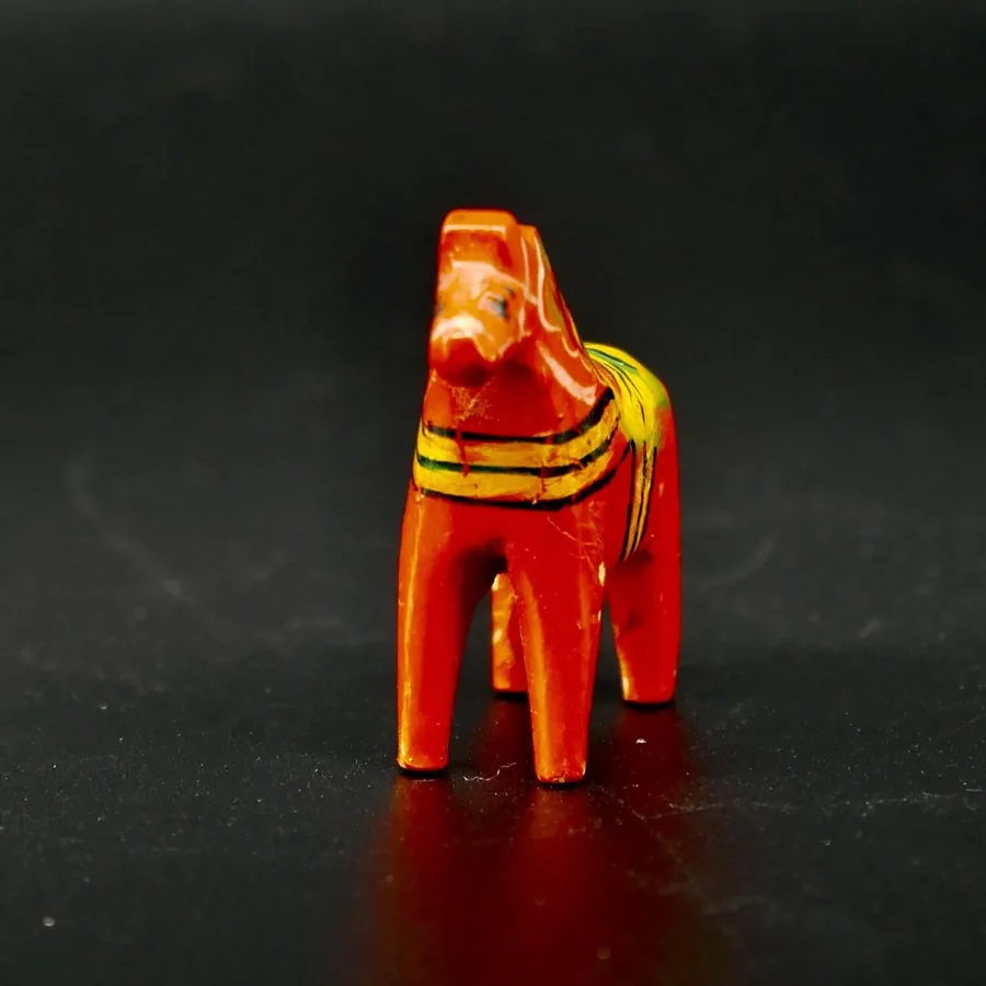 Rear view of miniature red Dala horse displaying back legs and lower body proportions with traditional painted details