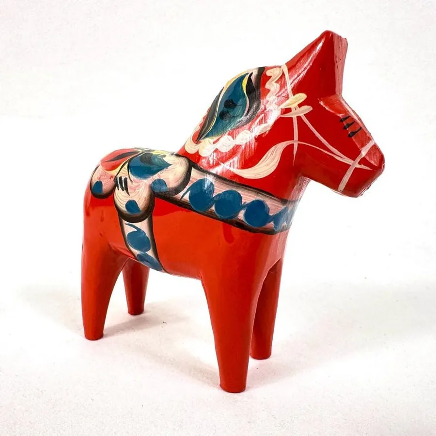 Red wooden Dala horse featuring carved head detail with alert expression, traditional folk art proportions