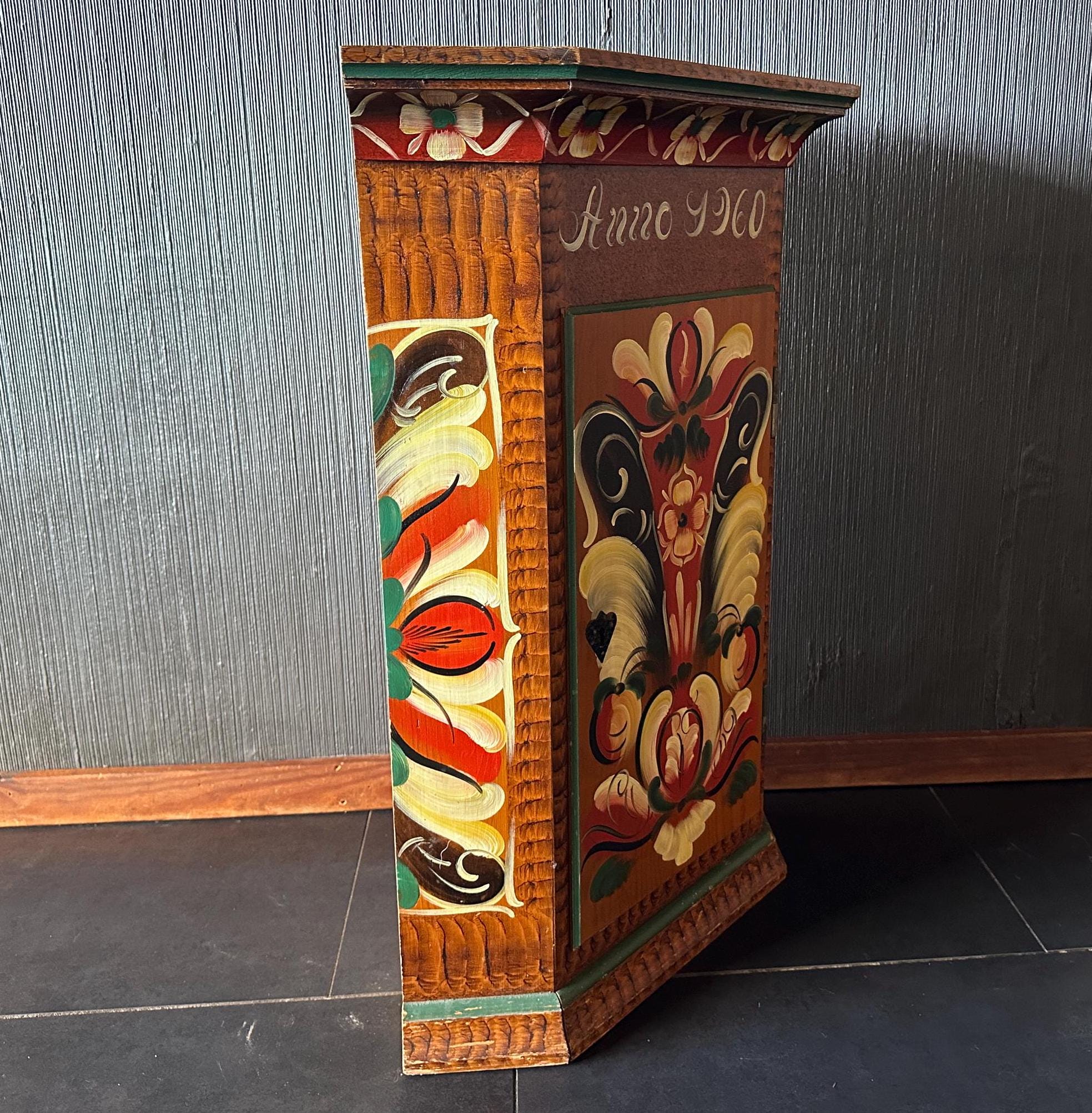 Side profile of ornate painted cupboard revealing full height proportions and layered kurbits designs along vertical edge pan