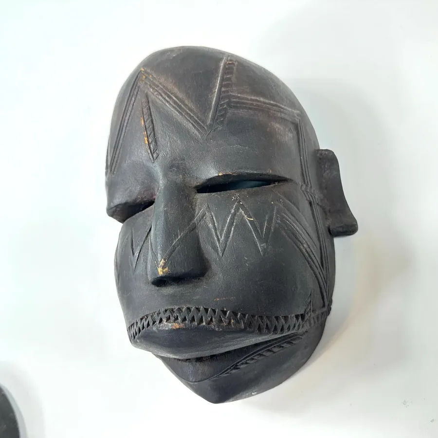 Side profile of vintage mask showing pronounced nose, carved ear protrusion, geometric cheek patterns, and traditional propor