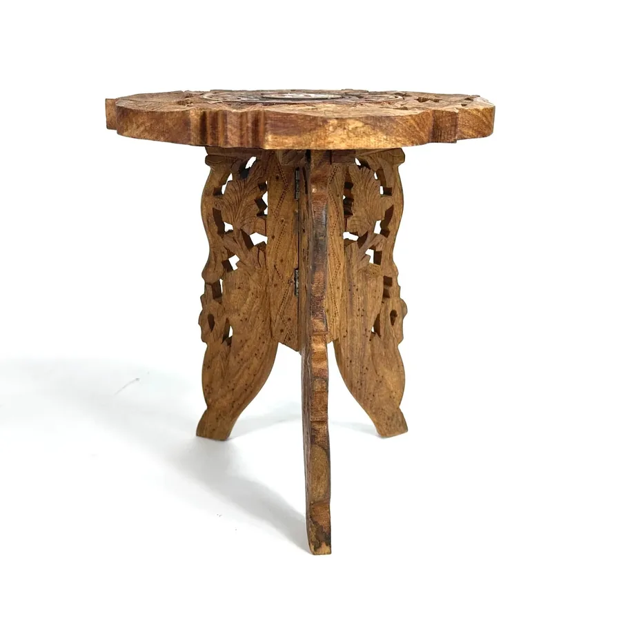 Side profile of wooden tripod stand displaying carved leaf patterns on supporting legs and tapered design