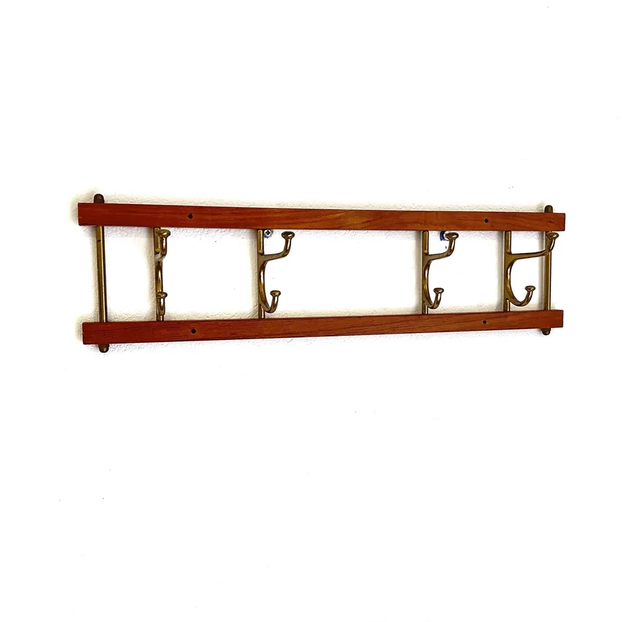 Skoglund Sweden folding coat rack in teak wood and brass, shown fully extended with four decorative hooks against neutral bac