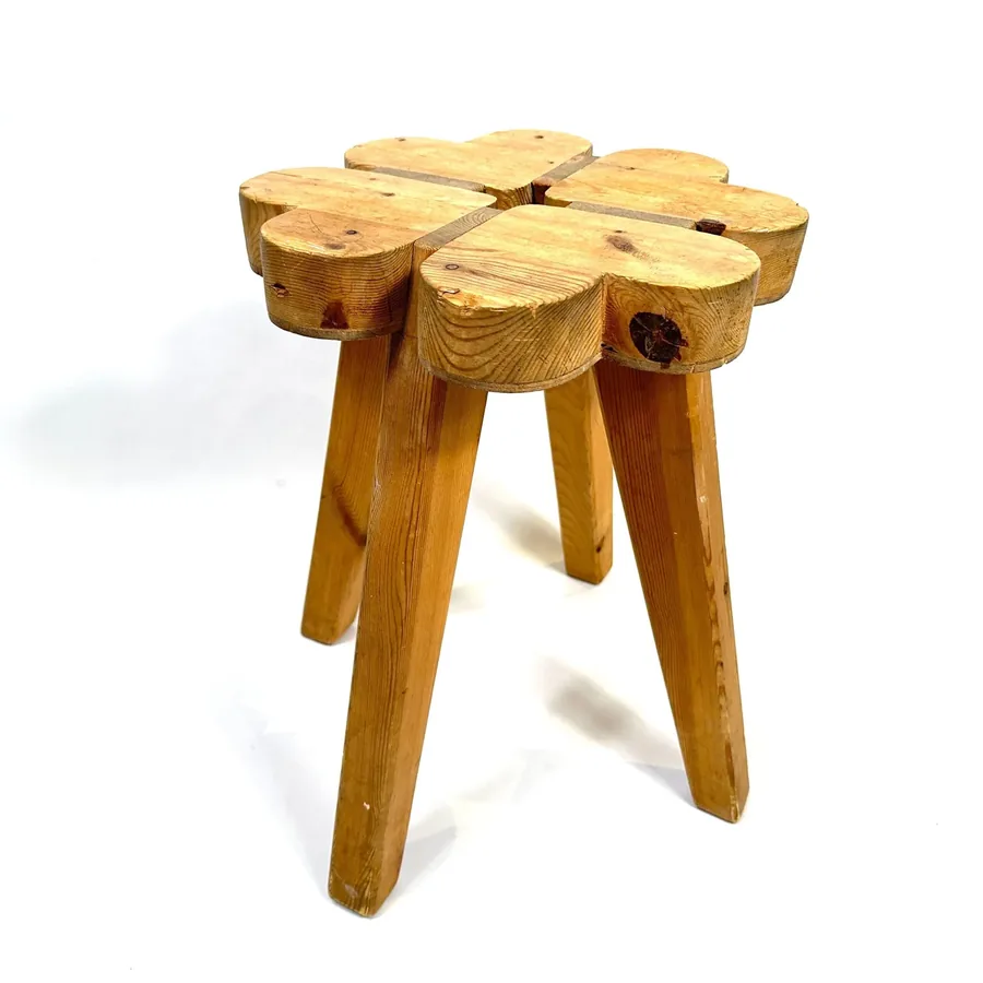 Swedish wooden stool with four-part clover-form seat and tapered legs, solid wood construction, three-quarter view