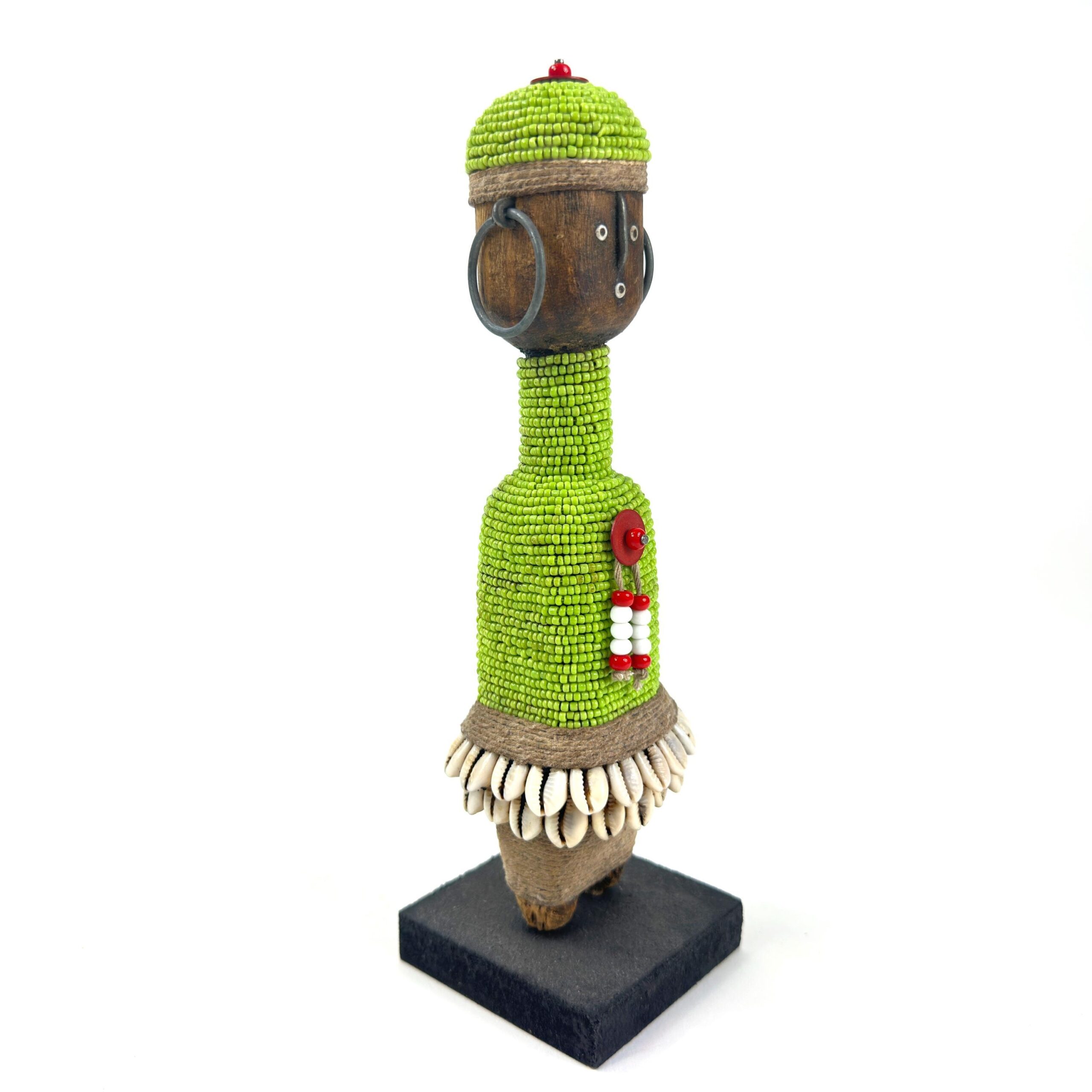 Three-quarter angle of beaded African doll showing full form, carved wood face with side profile visible, green beaded cylind
