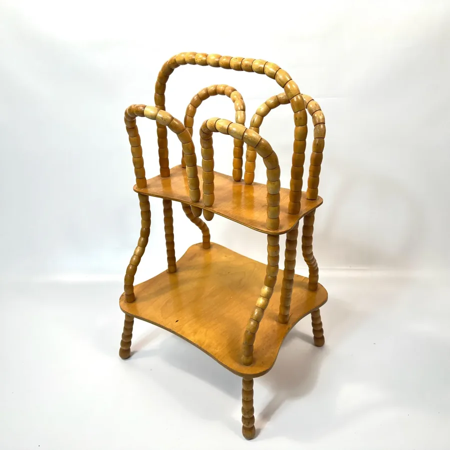 Three-quarter front-right angle showing full depth of shelves and sculptural frame of wooden mid-century rack