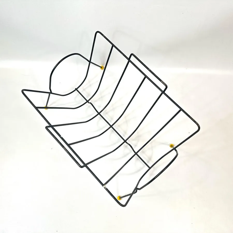 Top-down overhead view of 1960s wire magazine rack showing compartment layout and circular structural elements