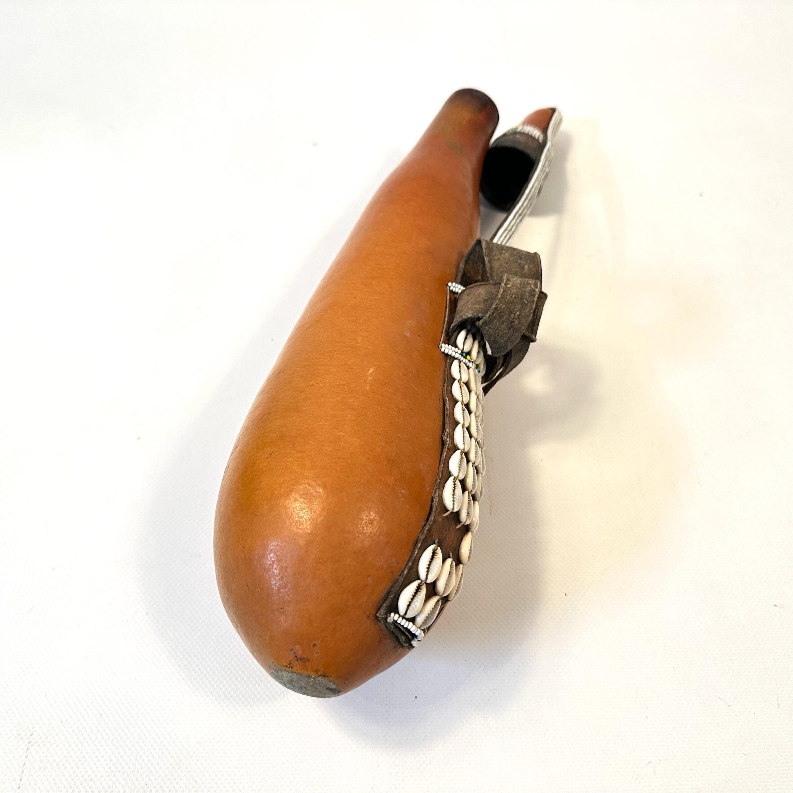 Tribal gourd vessel, overhead angled view, complete cowrie shell and bead decoration visible, rich wood patina