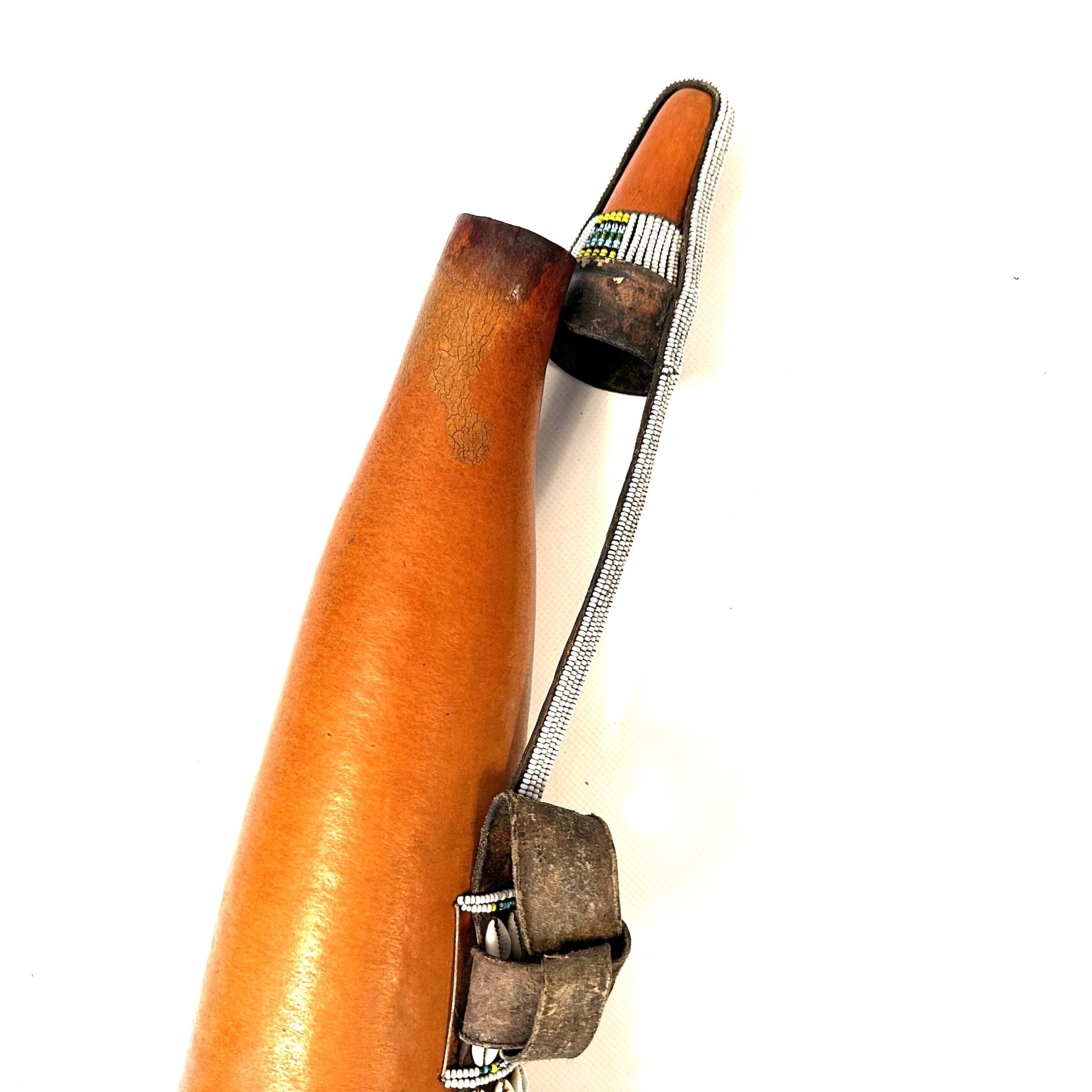 Tribal water container tilted view, full beadwork band visible, leather mounting hardware detail, natural wood aging