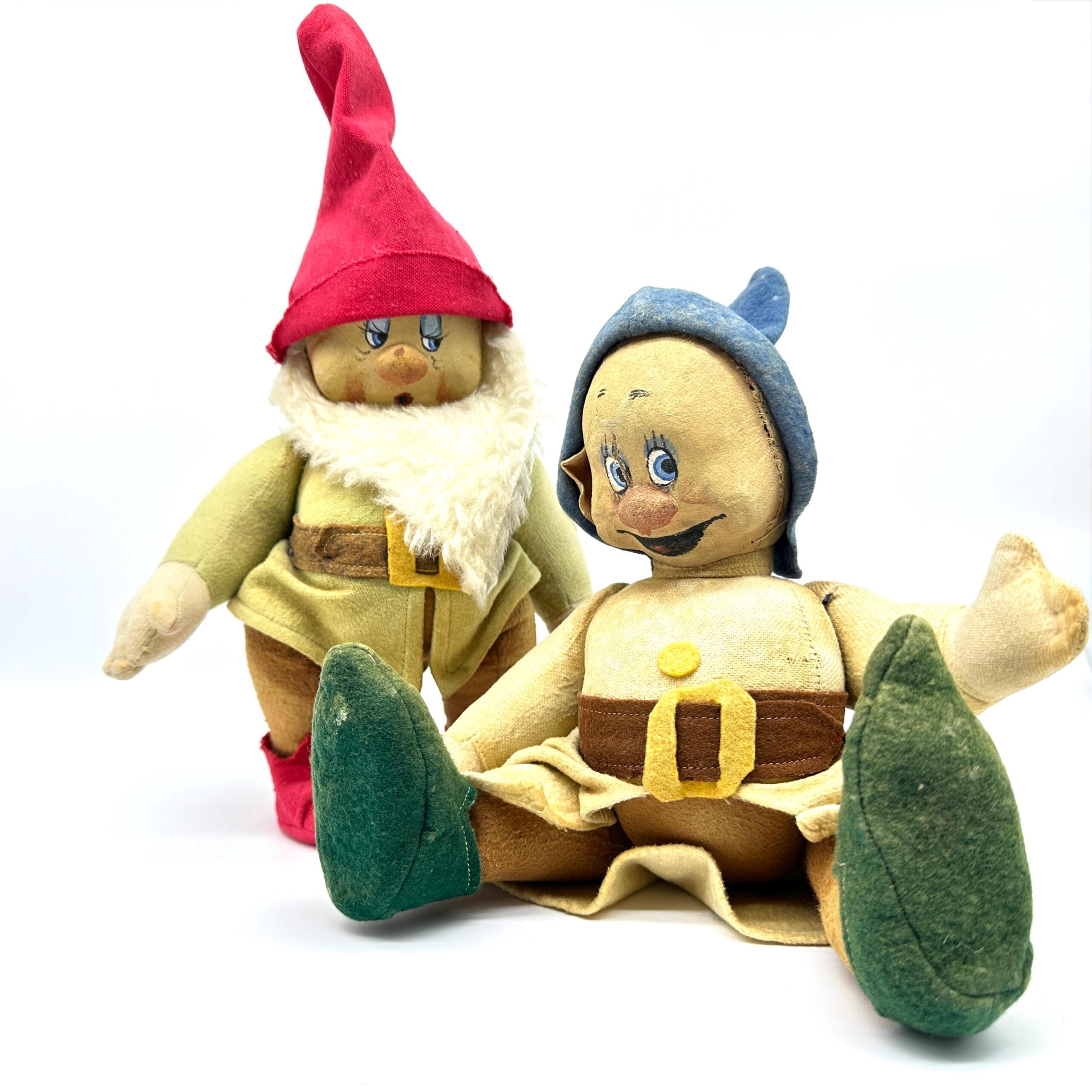 Two vintage dwarf dolls together: one with red pointed hat and white beard, one with blue hood, both in yellow dresses with p