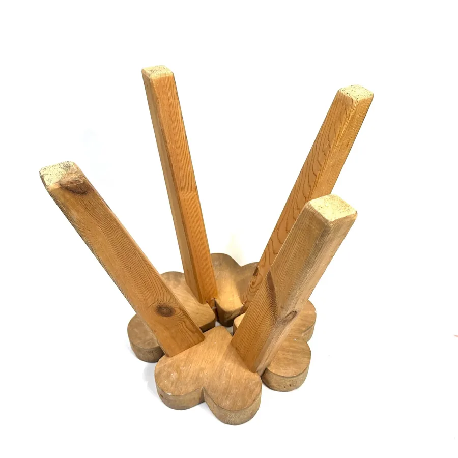 Underneath view of wooden stool showing four tapered legs meeting seat base and joint construction detail