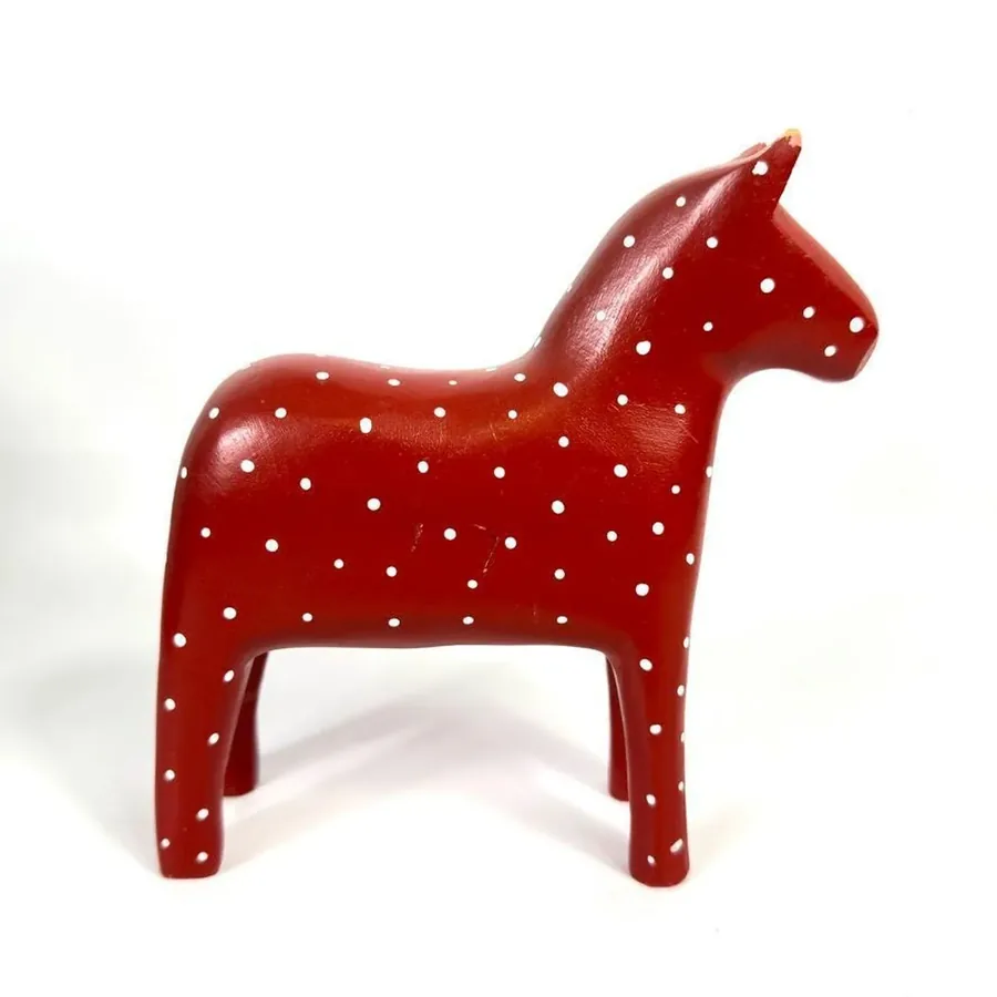 Vintage 1970s Swedish Dala horse, red wood with white polka dots, side profile view showing classic folk art craftsmanship