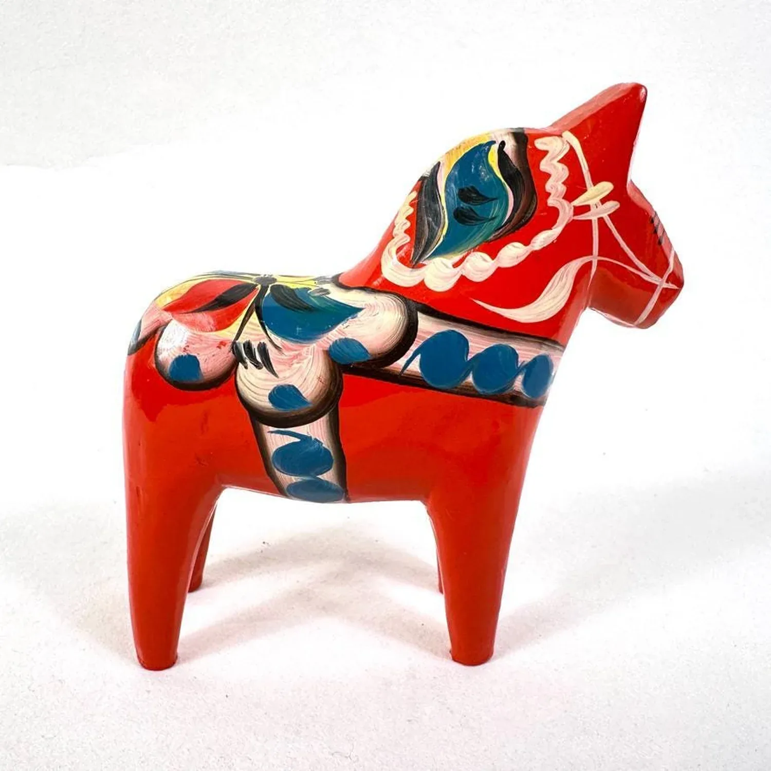 Vintage Swedish Dala horse, hand-painted red wood with traditional kurbits floral motifs in blue, yellow, and cream, front th