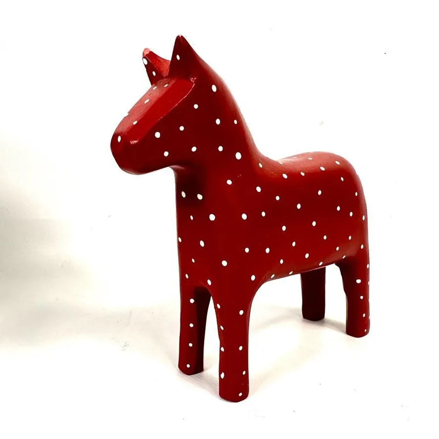 Vintage Swedish horse figurine in red wood with white polka dots, frontal view showing forward-facing stance