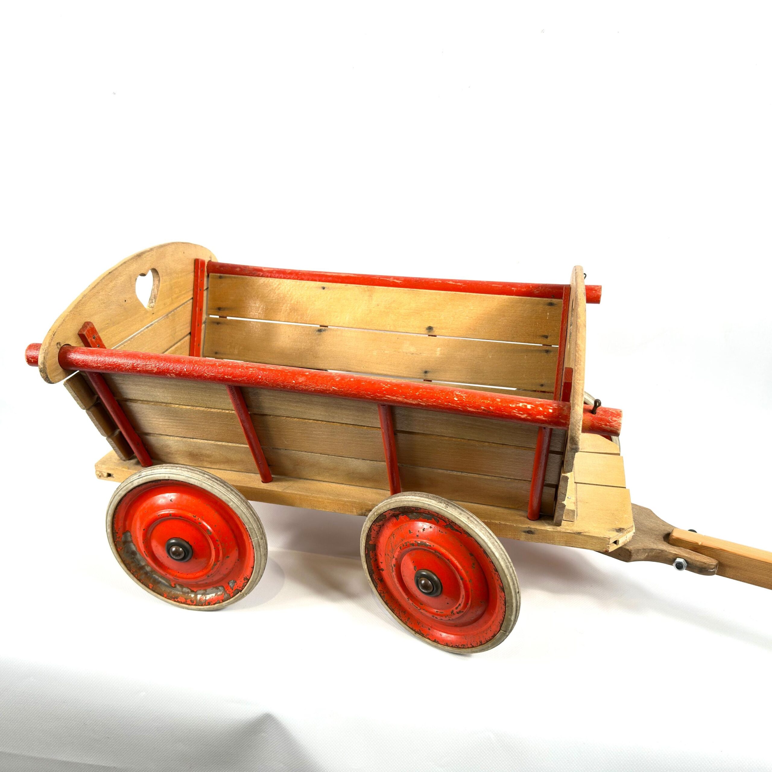 Wagon rear view showing curved wooden end panel with hole detail, red frame bands, and both red metal wheels