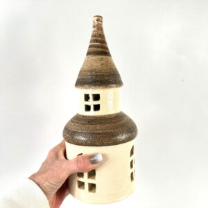 Vintage 1970s Brita Dals ceramic tower candle house with cream stoneware base, striped brown roof, and window cutouts, held i