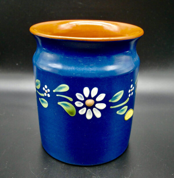 Frontal view of vintage Swedish ceramic pot displaying symmetrical white flower arrangement on matte cobalt blue surface