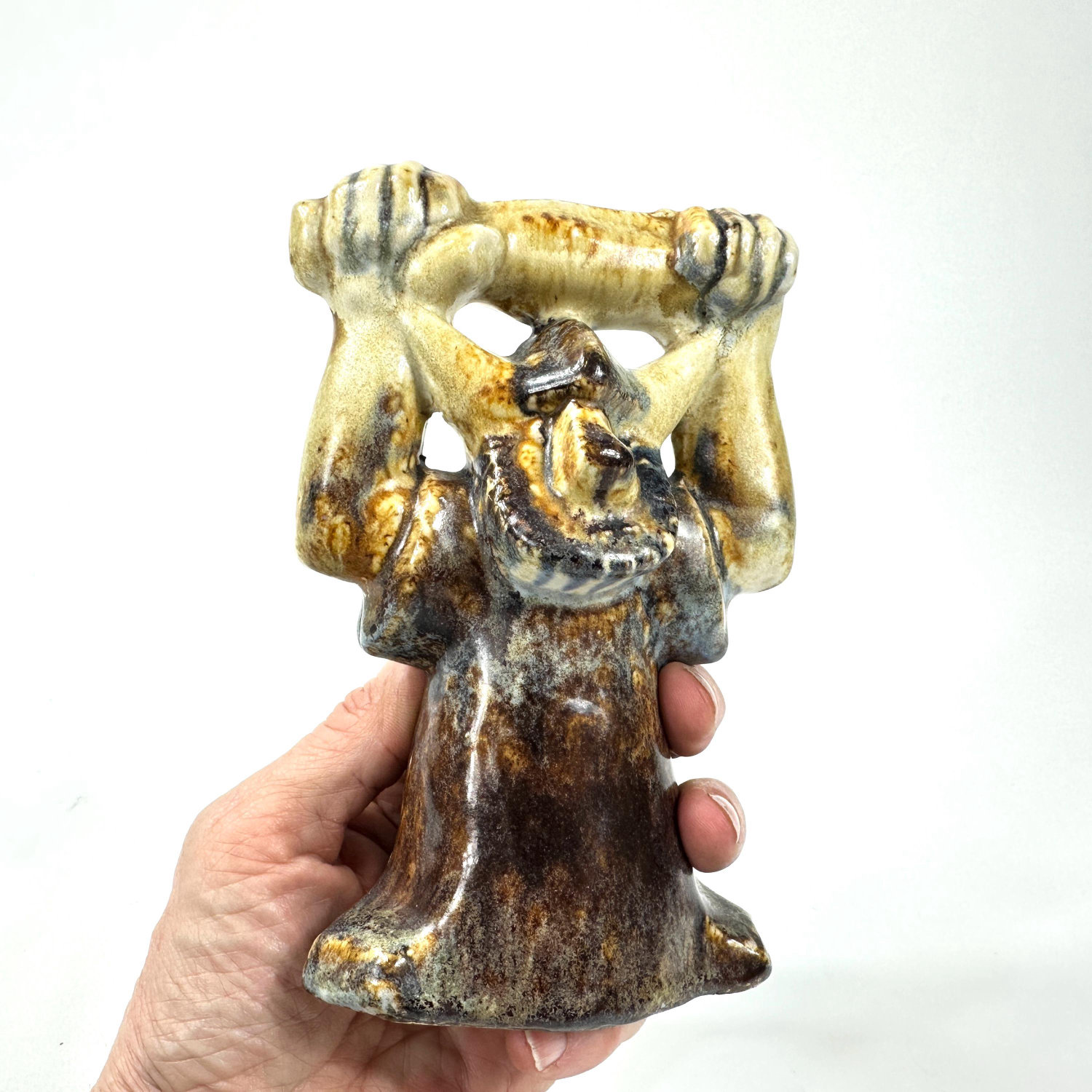 1970s Swedish ceramic Viking figure with raised arms, glazed stoneware, held in hand showing golden upper body and dark patin