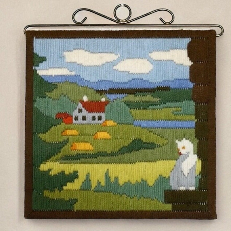 1970s woven tapestry with alert cat on fence overlooking rolling Swedish hills, trees, cottage, and blue water