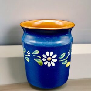 Vintage Swedish blue ceramic pot with white daisy flowers and golden rim, front three-quarter view showing full folk art desi
