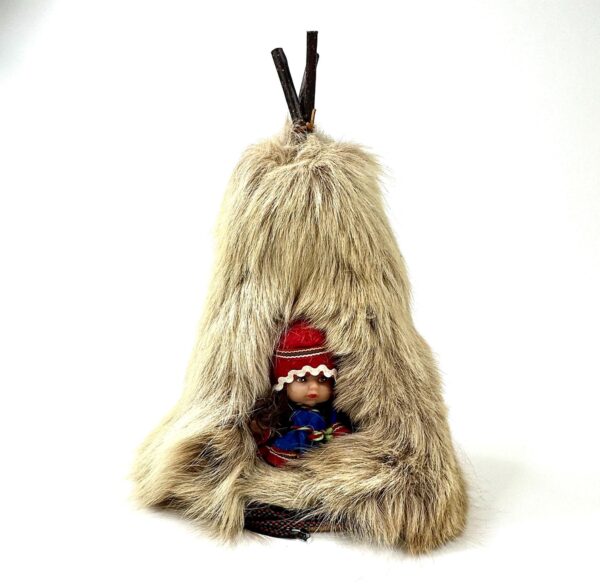 Vintage Sami doll in traditional red and blue clothing seated inside handcrafted reindeer skin teepee with natural wood poles
