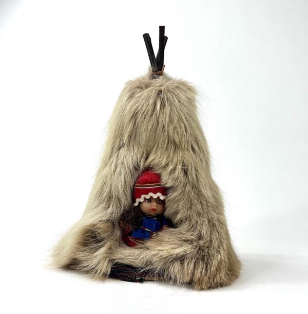 Lapland reindeer skin teepee with doll nestled inside, shot from front showing natural fur texture and wood frame silhouette