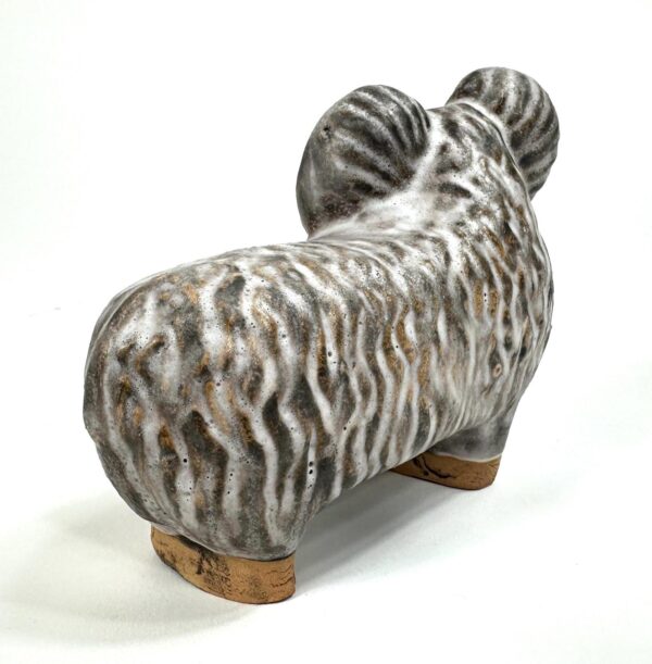 Right side profile of vintage ceramic sheep figurine with linear texture pattern and wood base details