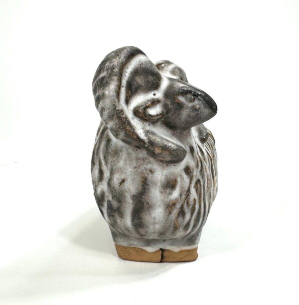 Close-up front view of sheep's face with expressive features and textured ceramic surface detail