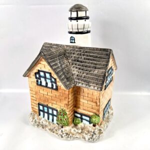 Vintage ceramic lighthouse cookie jar, hand-painted brick cottage with slate roof, cream and terracotta tones, full frontal v