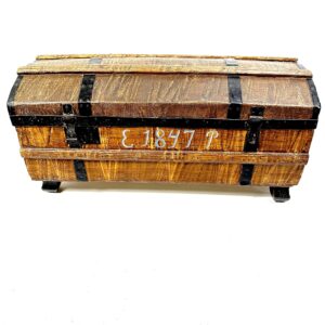 Wooden domed-lid trunk with black metal straps and '1847' marking, rich grain texture, side handles, rustic European storage