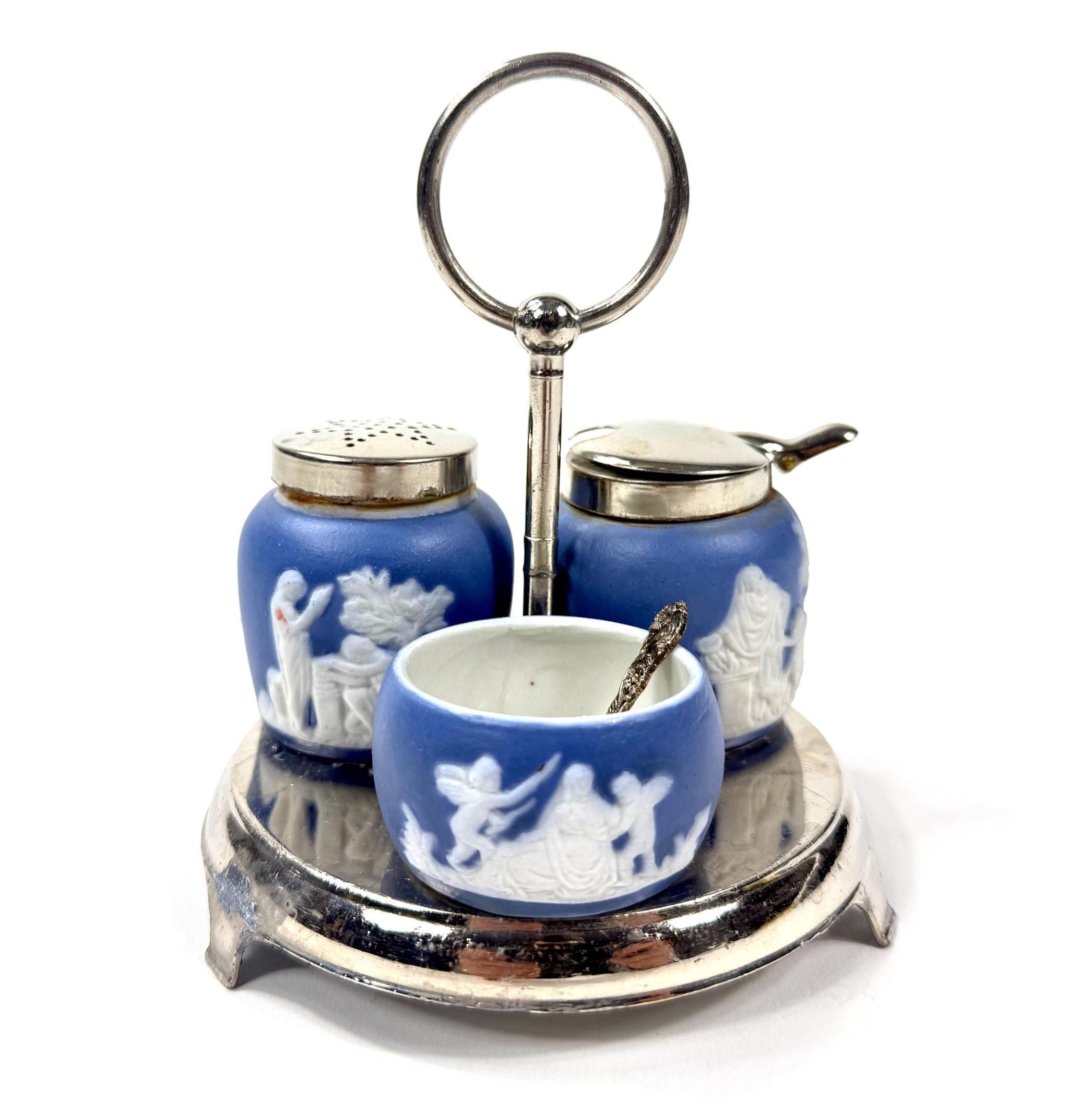 Adams Tunstall Jasperware cruet set: cobalt blue with white relief figures, silver metal stand, three ceramic vessels with ma