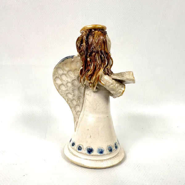 Angled view of ceramic angel displaying full wing detail, spaghetti hair movement, and cone-shaped cream body with blue base
