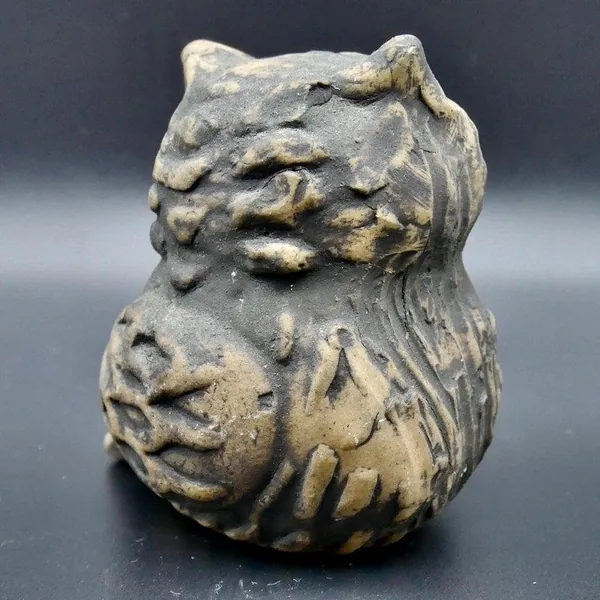 Back angled view of pottery owl with visible carved plumage texture and artist's maker mark inscription on rounded form