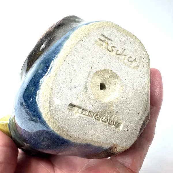 Base of vintage Fischer pottery bird with maker\'s mark, showing Ego Stengods studio label and artist signature in relief