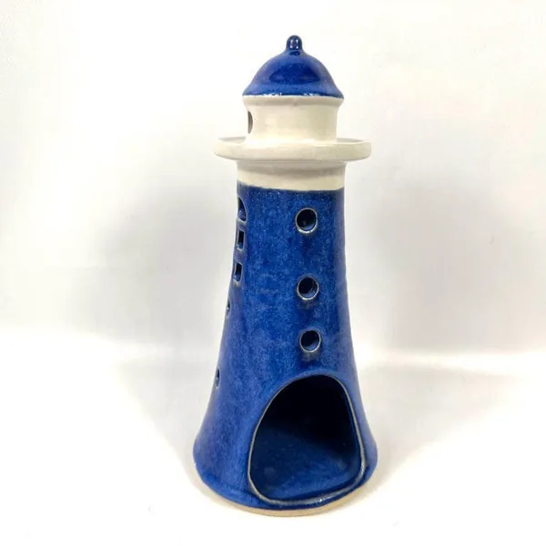 Base view of blue ceramic lighthouse holder showing wide opening and numbered pottery mark on cream underside