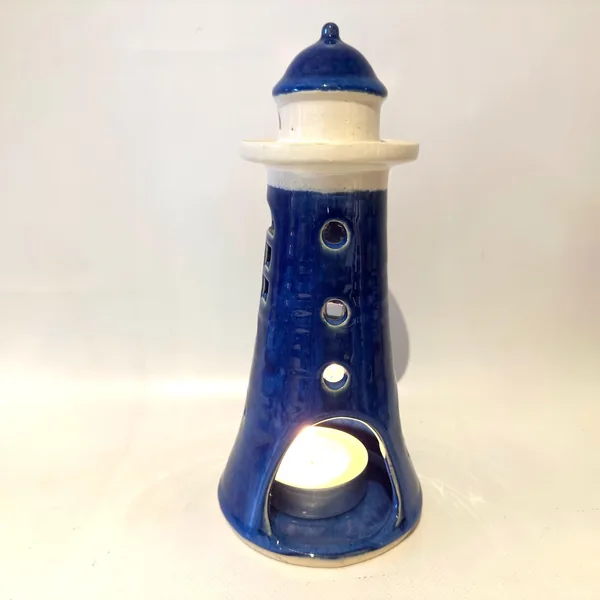 Blue ceramic lighthouse holder with front aperture opening, showing hollow interior cavity for tealight placement