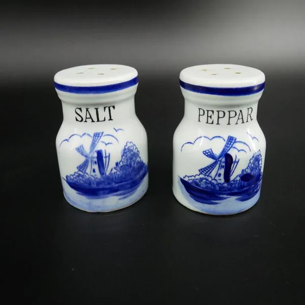 Both shakers standing side by side showing matching cobalt blue rims, symmetrical forms, and contrasting labels