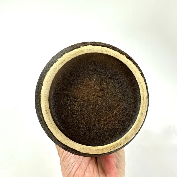 Bottom base view of vase showing unglazed brown stoneware, cream-colored rim band, impressed maker's mark and form number