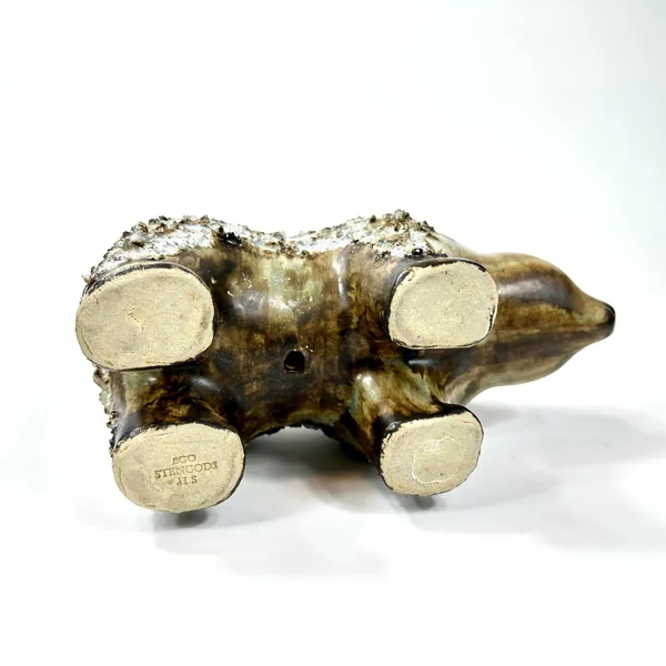 Bottom view of ceramic bear showing maker's mark and base, revealing wooden platform details and pottery signatures