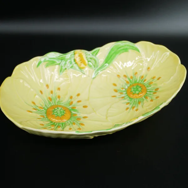 Carlton Ware Buttercup bowl angled view, embossed petal edges and gloss finish on yellow earthenware with visible two flower