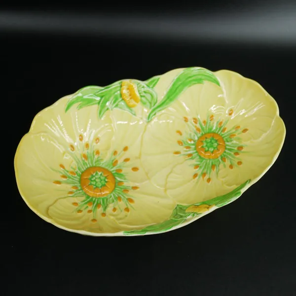 Carlton Ware Buttercup bowl overhead view, two embossed flowers with green leaf details and speckled orange centers on pale y