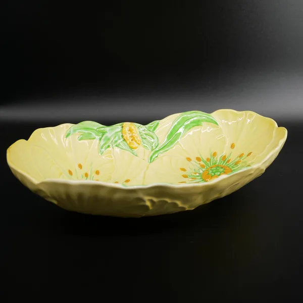 Carlton Ware Buttercup bowl side profile, yellow embossed petals with green stems and yellow-orange flower centers in soft fo