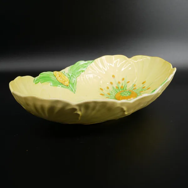 Carlton Ware Buttercup bowl three-quarter view, soft yellow tone with embossed texture and single visible flower motif with g