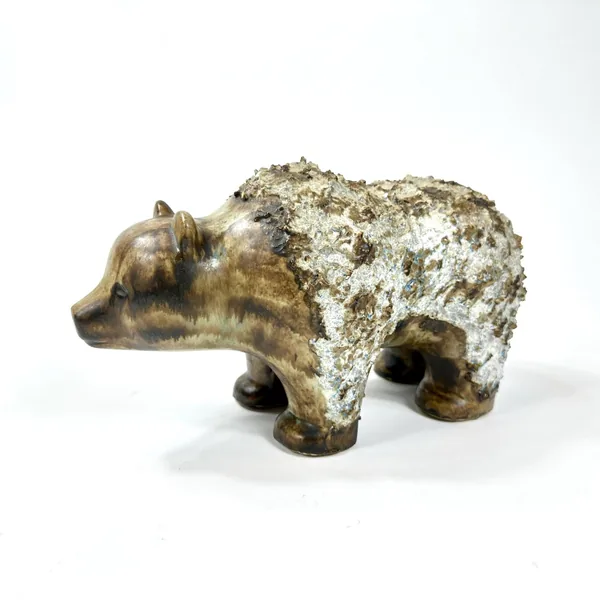 Ceramic bear figurine displayed in profile, showing sculpted facial features and textured stoneware body from side angle