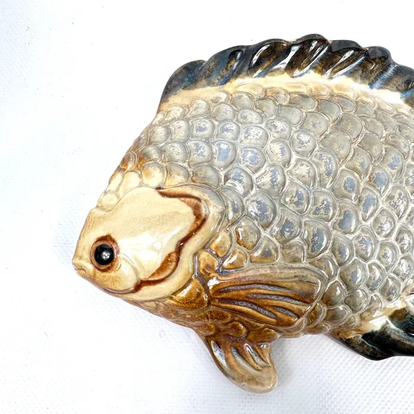 Ceramic fish plaque profile closeup showing defined facial features, eye detail, and mouth expression