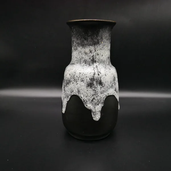Ceramic vase profile angle showing curved silhouette, lava glaze texture, and tapered black base design