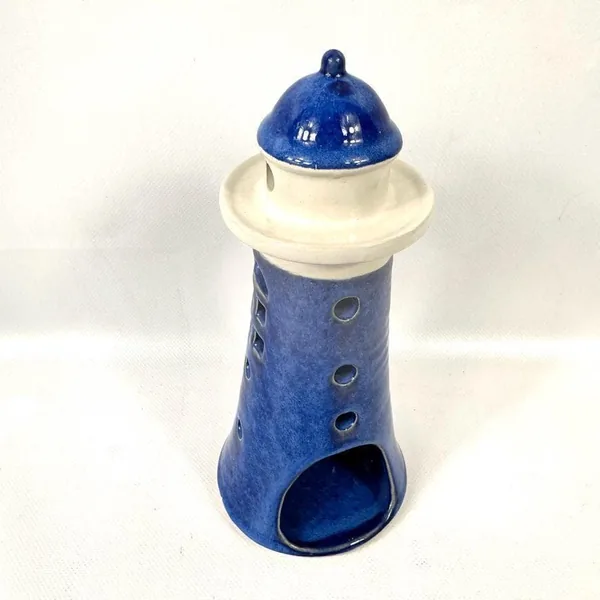 Clear front view of ceramic lighthouse interior showing hollow barrel chamber and side port opening for candle glow
