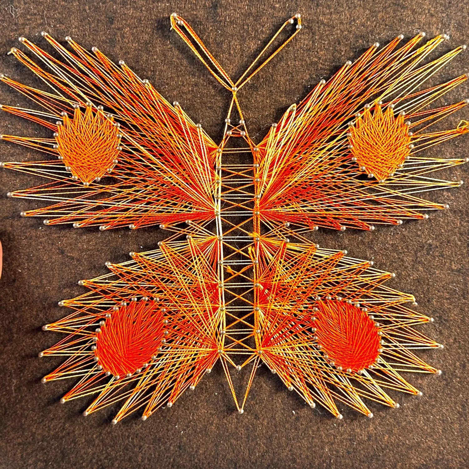Close-up front view of vintage butterfly string art showing detailed thread pattern and color gradations