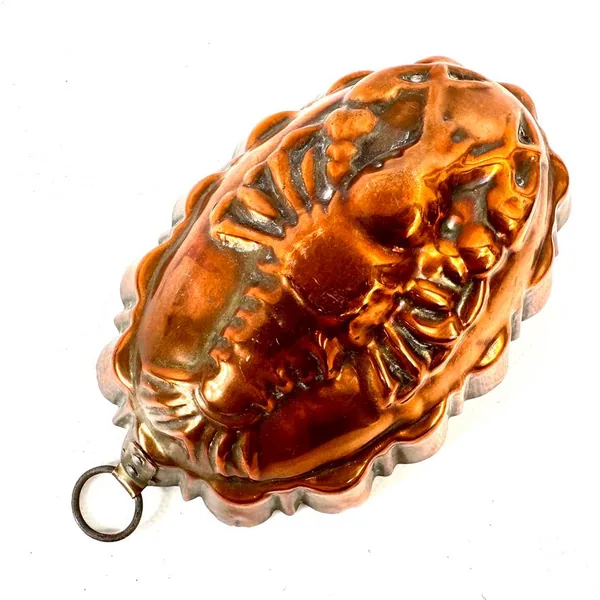 Copper lobster mold top view revealing detailed shell carving and warm metallic patina
