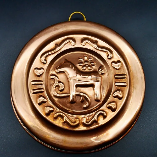 Copper mold front view showing Dala Horse with decorative Roman numerals border design